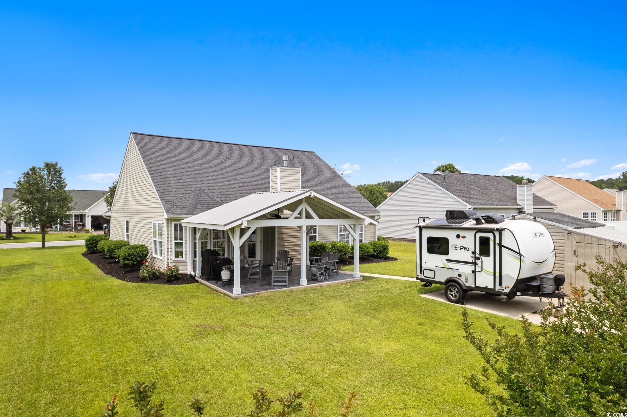 620 Seth Lane Longs, SC 29568 - Photo 26 of 35 Rear view of house featuring a yard, roof with shingles, a patio area, a gazebo, and a chimney