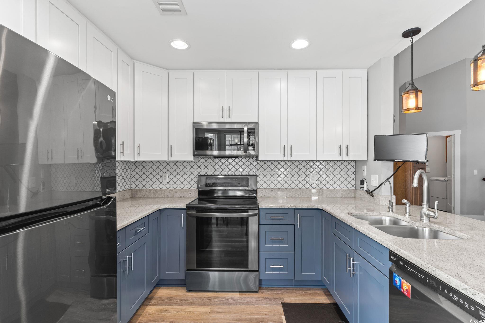 620 Seth Lane Longs, SC 29568 - Photo 8 of 35 Kitchen featuring stainless steel appliances, blue cabinetry, white cabinetry, a sink, and decorative backsplash
