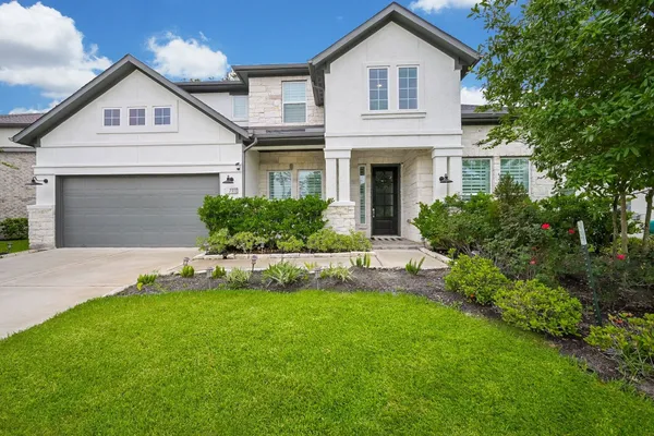 a front view of a house with a yard and garage