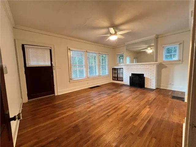 a view of empty room with wooden floor and fireplace