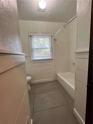 a bathroom with a tub a sink and a window
