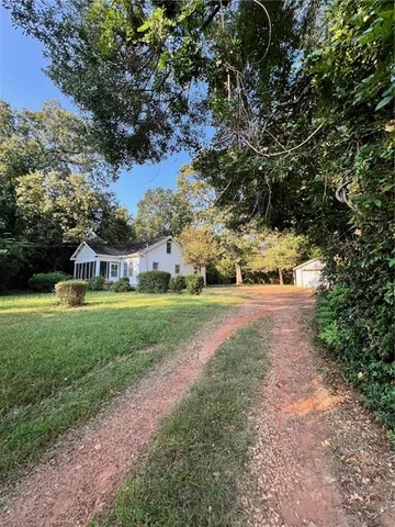 a view of yard with green space and trees around