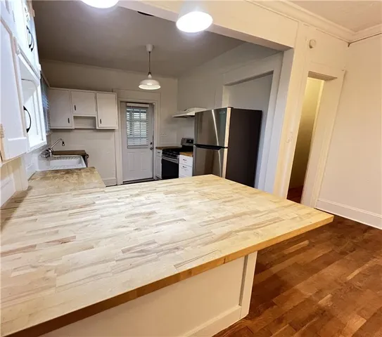 a large white kitchen with kitchen island a sink dishwasher a refrigerator and a stove