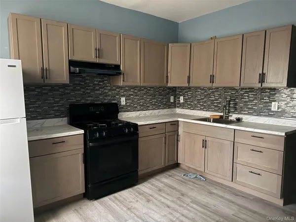 a kitchen with white cabinets sink and stainless steel appliances