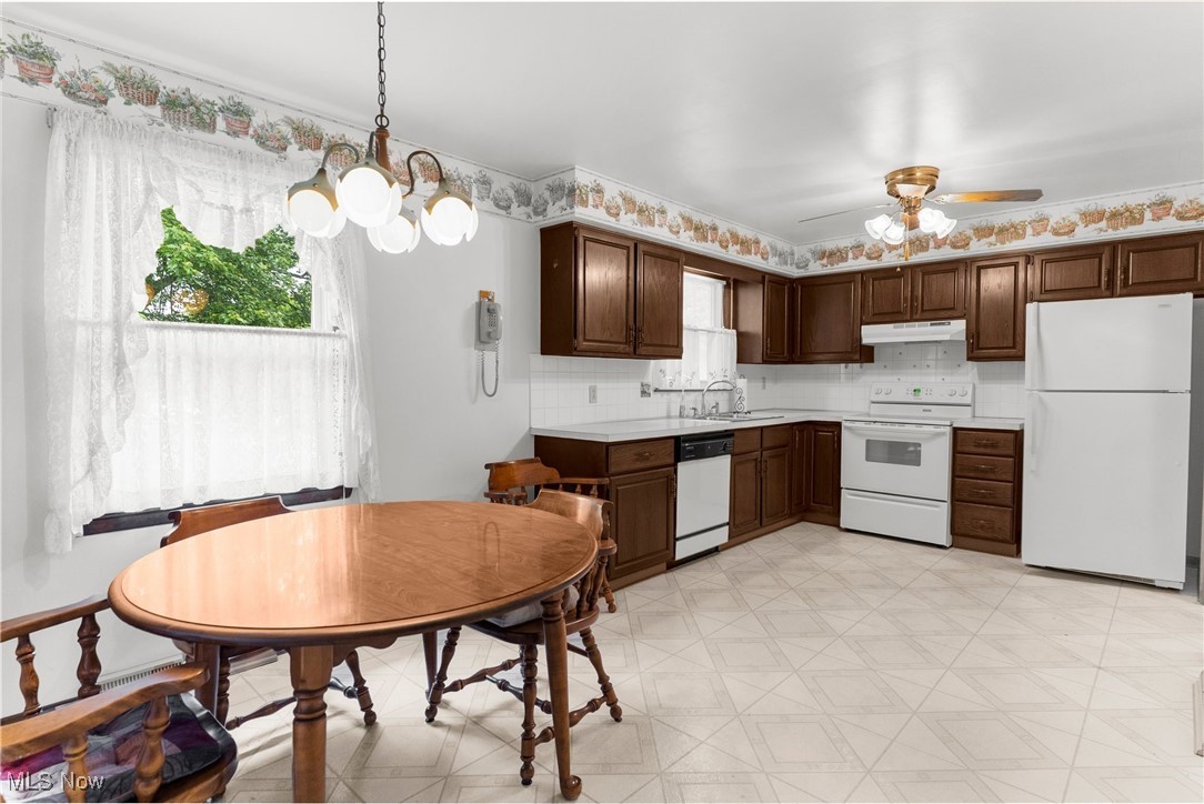 1295 Shields Road Youngstown, OH 44511 - Photo 8 of 27 Kitchen featuring white appliances, under cabinet range hood, light floors, light countertops, and a sink