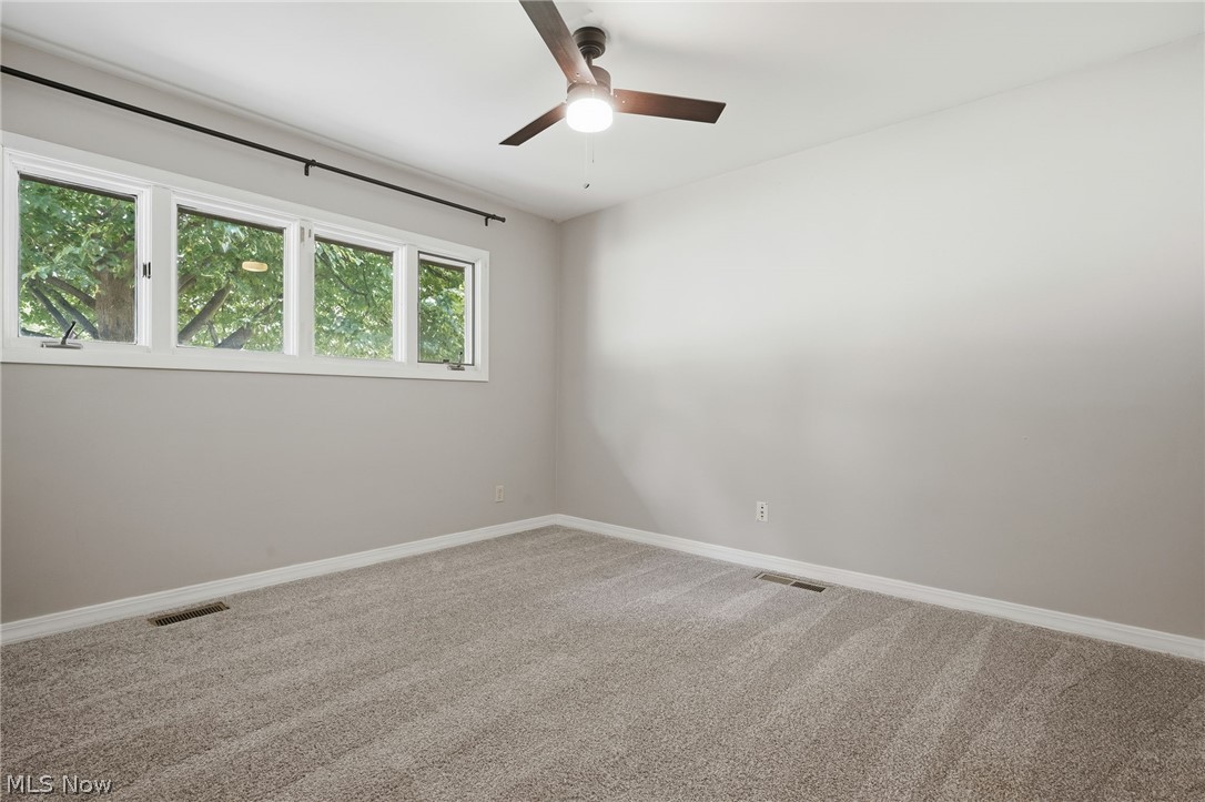 8160 Joyce Road Broadview Heights, OH 44147 - Photo 27 of 45 Room featuring neutral wall paint, light-colored carpet flooring, white trim, and a ceiling fan with light fixture