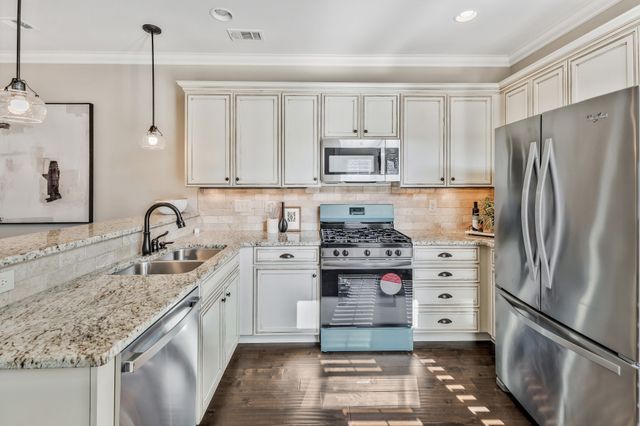 a kitchen with stainless steel appliances granite countertop a stove and cabinets