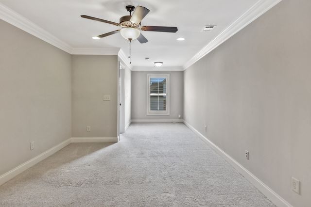 an empty room with closet and a ceiling fan