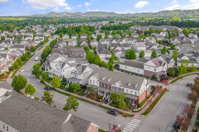 an aerial view of a city with lots of residential buildings ocean and mountain view in back