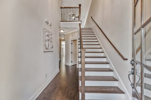 a view of staircase with wooden floor and white walls