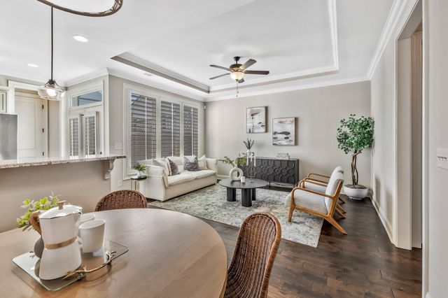 a living room with furniture kitchen view and a wooden floor