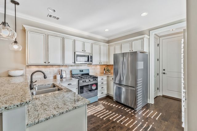 a kitchen with stainless steel appliances granite countertop a refrigerator stove and sink