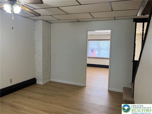 a hallway with wooden floor chandelier and entryway