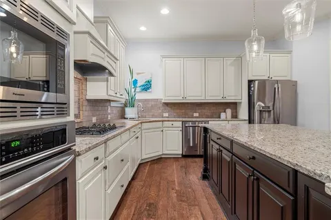 a dining room with furniture a chandelier and wooden floor