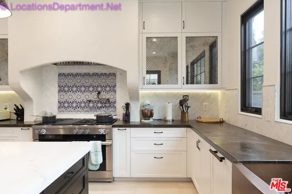 a kitchen with granite countertop a sink stove and cabinets