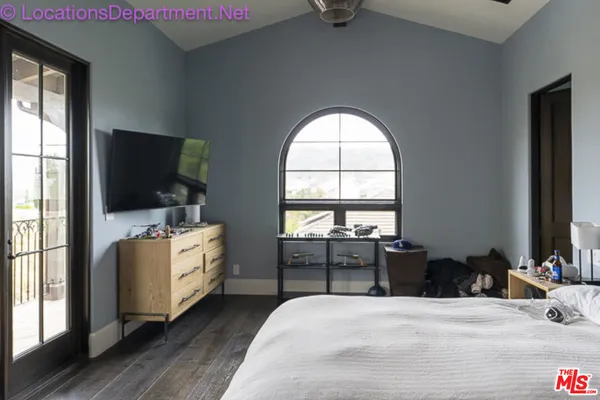 a bedroom with furniture and a flat screen tv