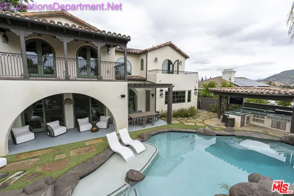 a view of a house with swimming pool and furniture
