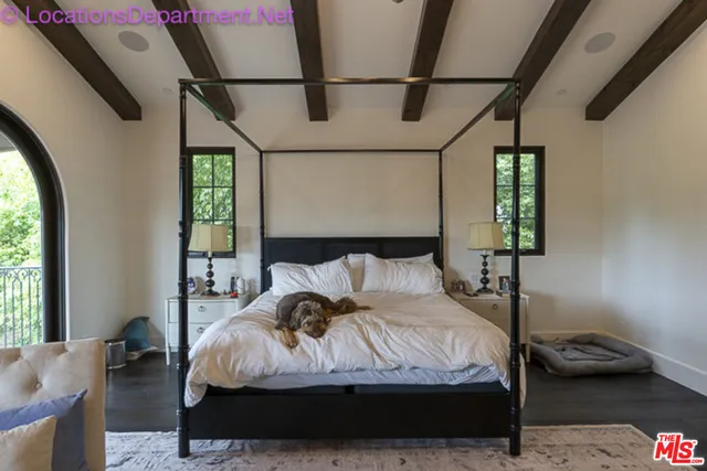 a bed sitting in a bedroom next to a window