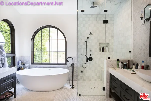 a bathroom with a tub a sink and mirror