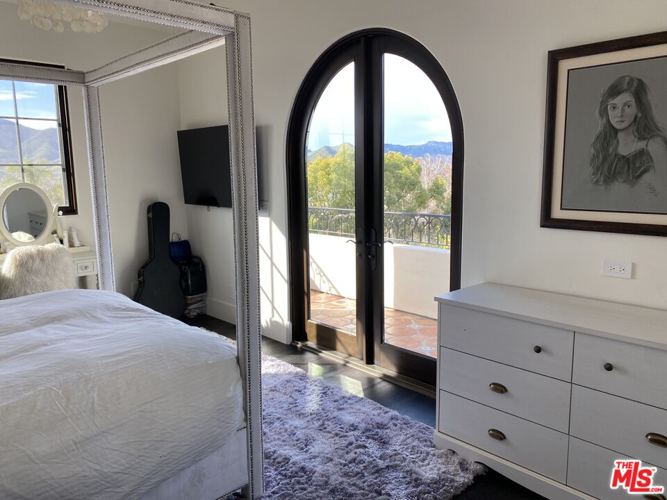 5861 Ridgebrook Drive Agoura Hills, CA 91301 - Photo 27 of 42 a bedroom with a bed and a large window with the outer view