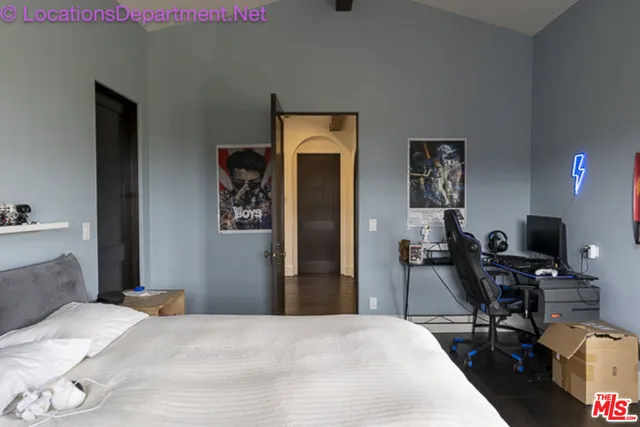 a bedroom with a bed and a computer on a table