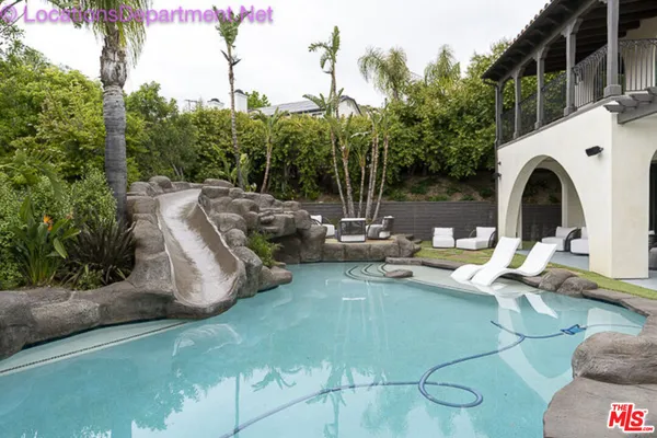 a view of a swimming pool with outdoor seating and plants