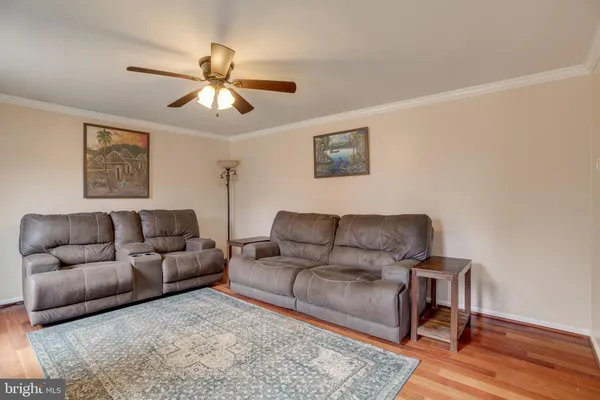 a living room with furniture a ceiling fan and a window
