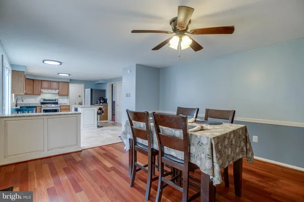 a kitchen with a stove a refrigerator and chairs