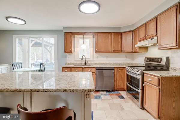 a kitchen with granite countertop a sink stove and refrigerator