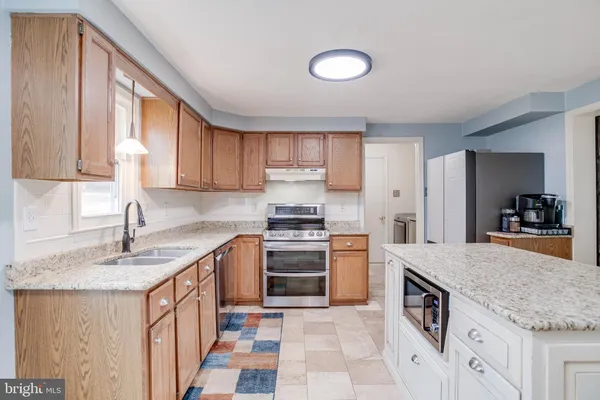 a kitchen with stainless steel appliances granite countertop a stove and cabinets
