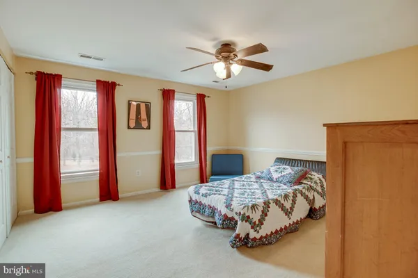 a bedroom with a bed and a ceiling fan