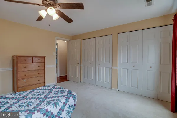 a bedroom with a bed a lamp and a dresser