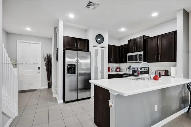 a kitchen with stainless steel appliances a refrigerator sink microwave and cabinets