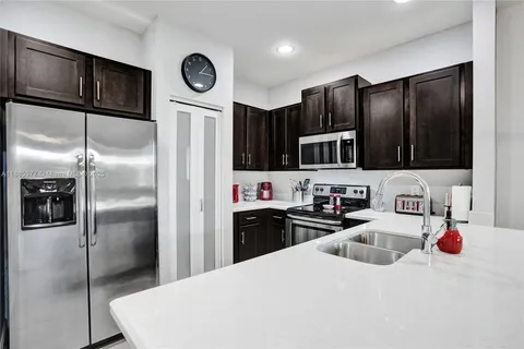 a kitchen with granite countertop a refrigerator and a sink