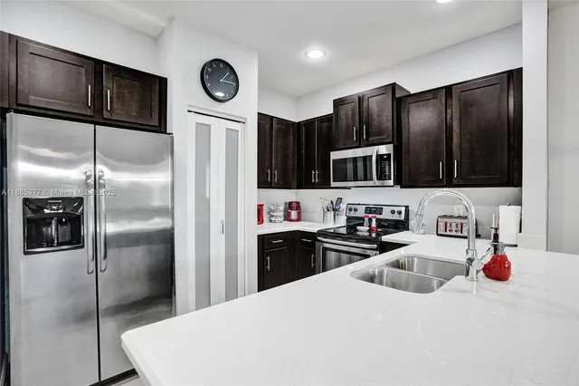 a kitchen with granite countertop a refrigerator and a sink