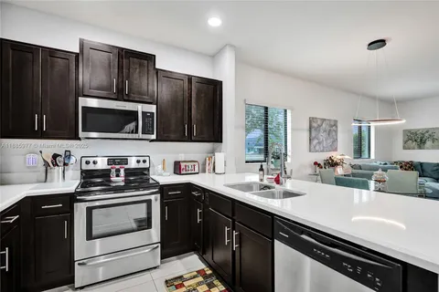 a kitchen with a sink stove top oven and refrigerator