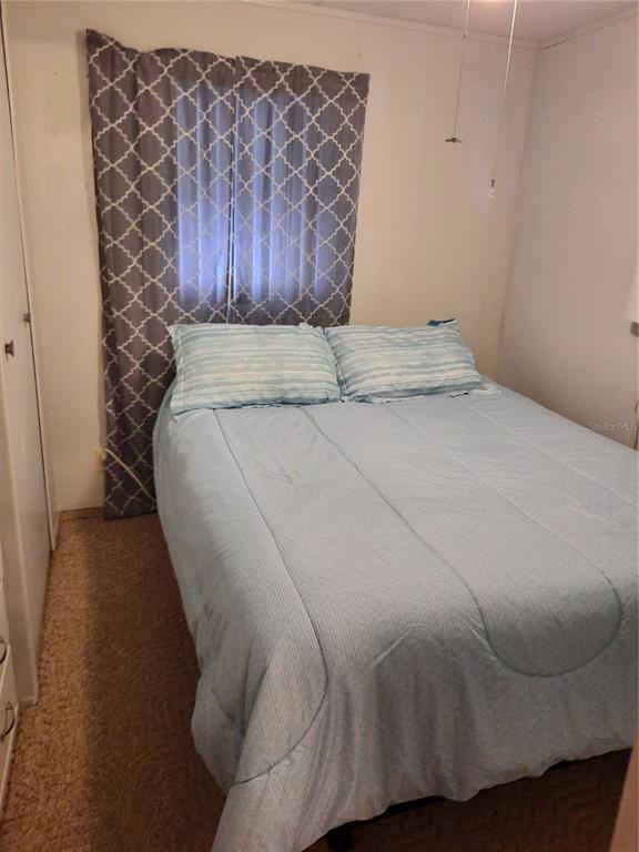 4 Palm Place Tavares, FL 32778 - Photo 16 of 20 a bed sitting in a bedroom next to a wooden cabinet