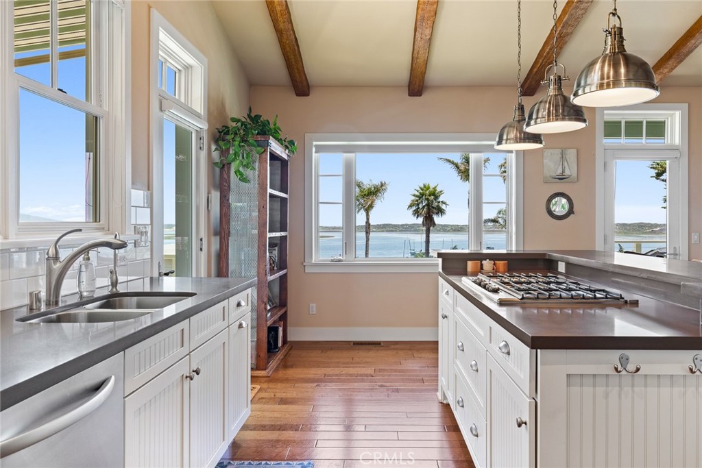 281 Main Street Morro Bay, CA 93442 - Photo 15 of 69 a kitchen with stainless steel appliances kitchen island granite countertop a stove a sink dishwasher and cabinets with wooden floor