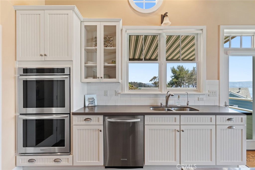 281 Main Street Morro Bay, CA 93442 - Photo 28 of 69 a kitchen with granite countertop white cabinets and stainless steel appliances