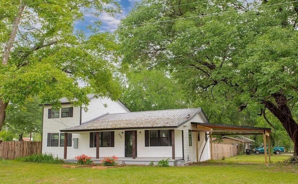 202 South Main Street Edgewood, TX 75117 - Photo 1 of 1 a view of a white house with a big yard and large trees