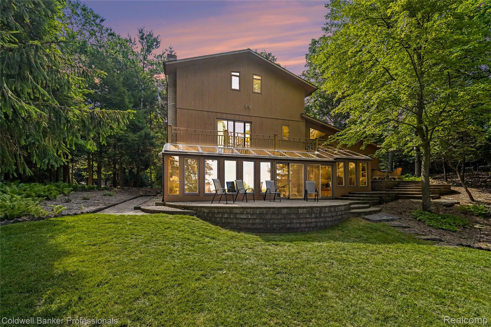 3583 Mitchell Road Metamora, MI 48455 - Photo 8 of 58 Multi-level exterior featuring a wood-panel facade, a glass-enclosed sunroom, and an upper-level balcony