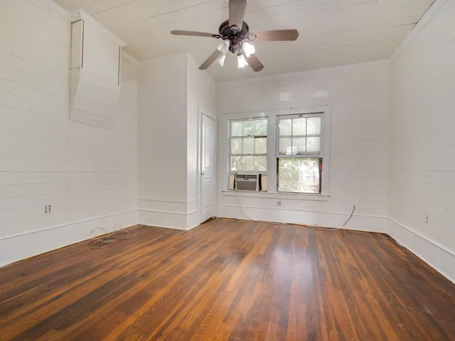 wooden floor in an empty room with a window