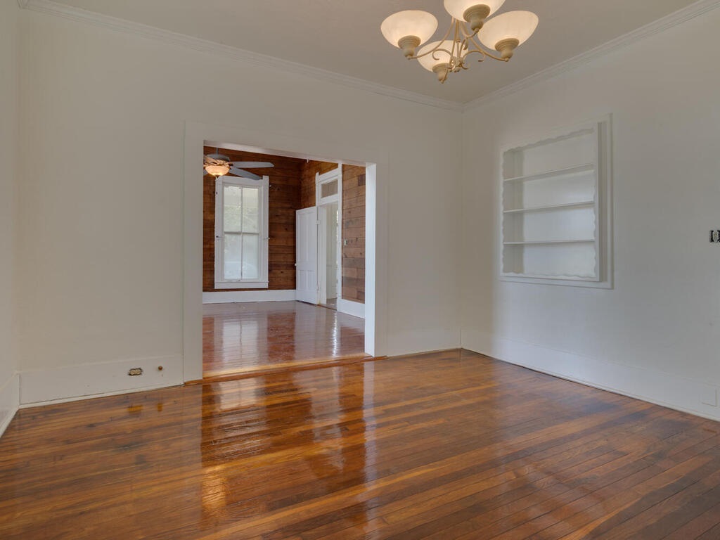 316 South Ave C, Unit B Elgin, TX 78621 - Photo 3 of 14 an empty room with wooden floor cabinet and windows