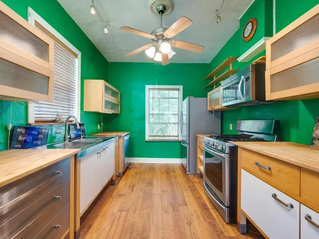 a kitchen with kitchen island a large counter space a sink and stainless steel appliances