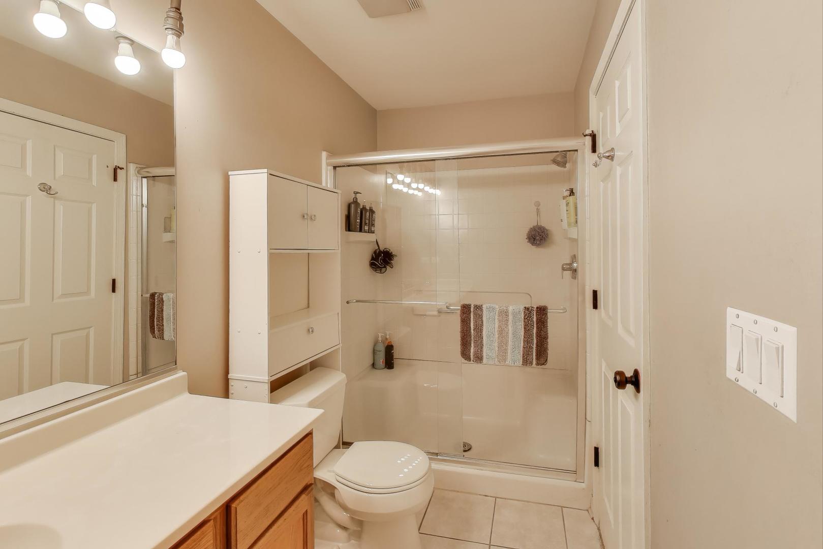 104 Waterbury Circle Oswego, IL 60543 - Photo 14 of 23 a bathroom with a granite countertop sink toilet and shower