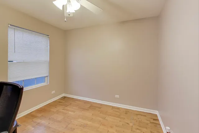 an empty room with a chandelier fan