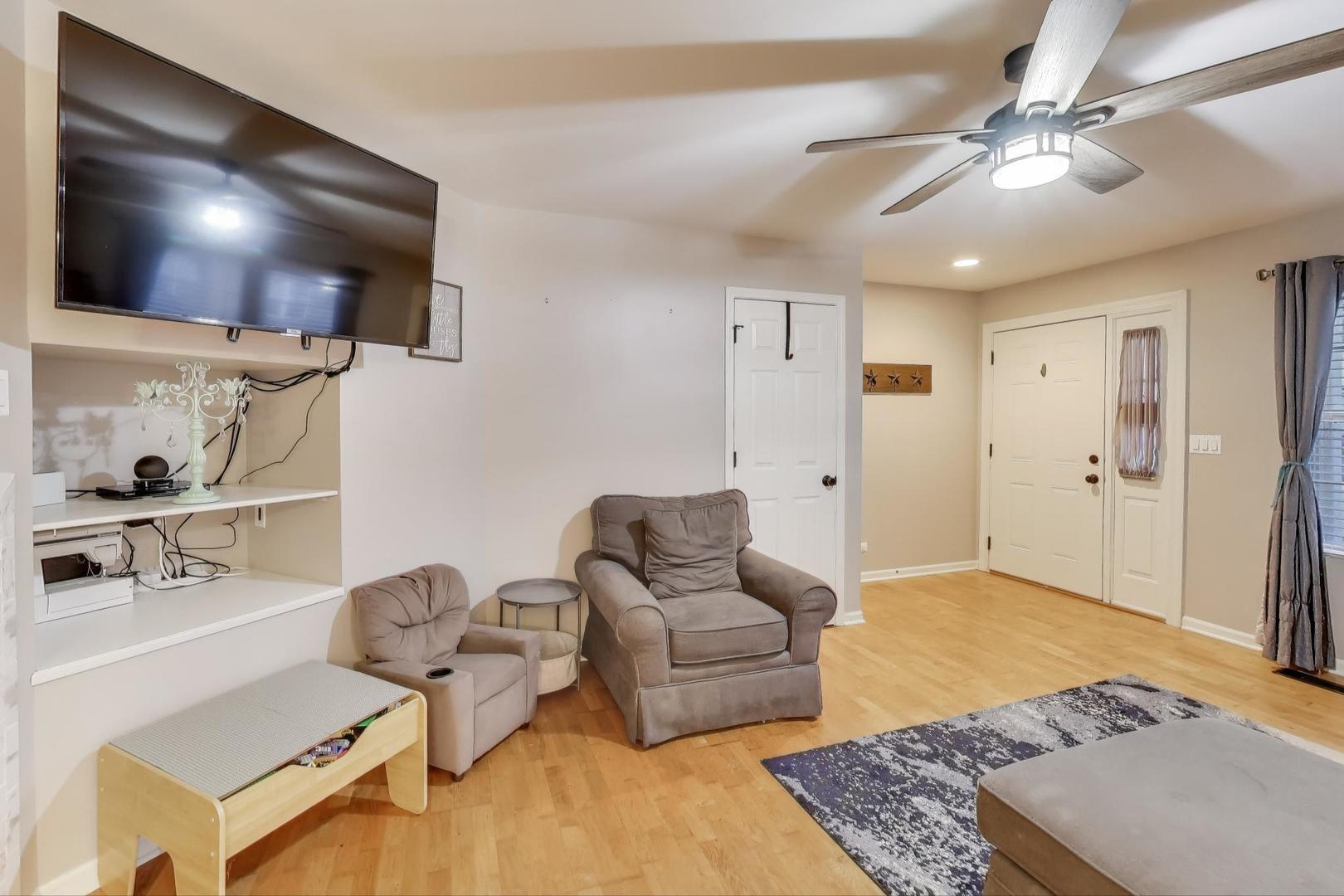 104 Waterbury Circle Oswego, IL 60543 - Photo 6 of 23 a living room with furniture and a flat screen tv