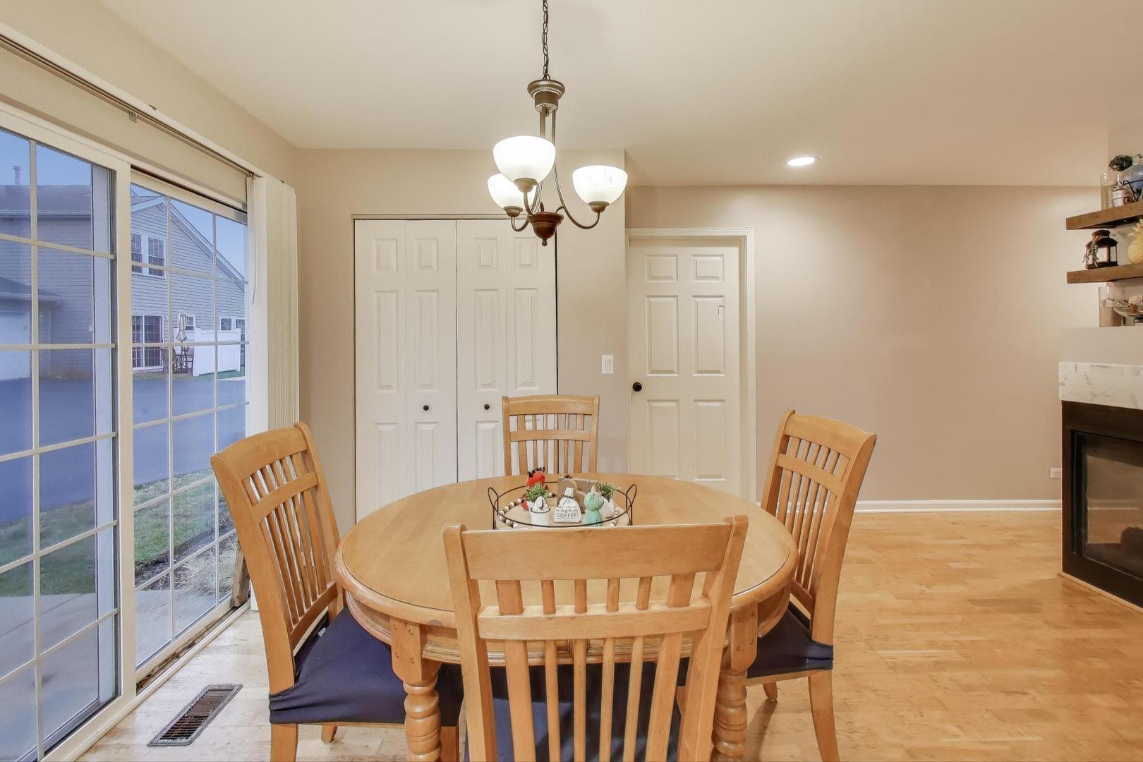 104 Waterbury Circle Oswego, IL 60543 - Photo 7 of 23 a view of a dining room with furniture wooden floor and a chandelier