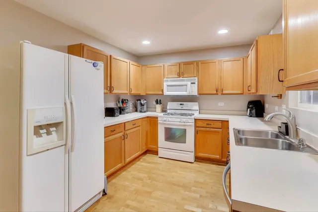 a kitchen with stainless steel appliances granite countertop a refrigerator sink stove and oven