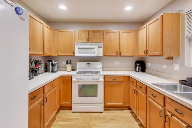 a kitchen with stainless steel appliances granite countertop a stove a sink and white cabinets